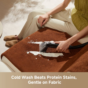 Steam spot cleaner wand cleaning a brown fabric cushion surface