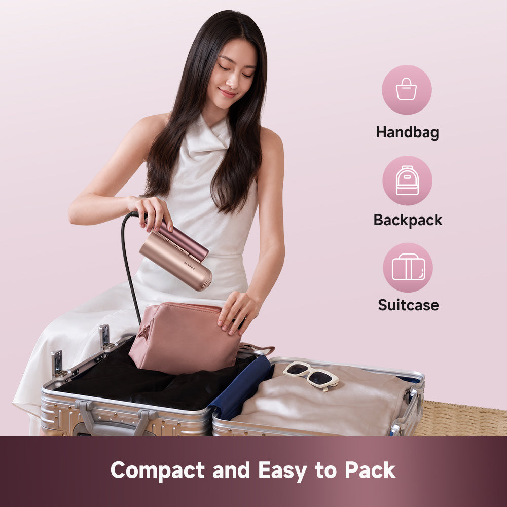 Rose gold handheld hair dryer held near compact carry bags
