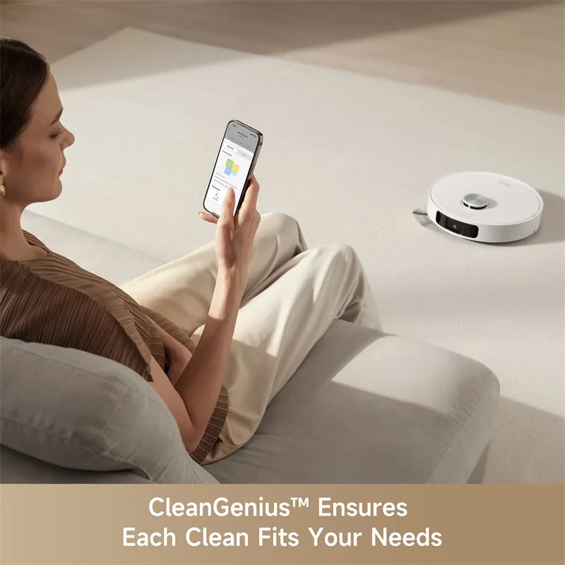 Robotic vacuum cleaning on living room floor, controlled from a smartphone.