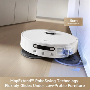 White robotic vacuum cleaning along a wall corner with mop pad in front.