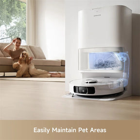 Robotic vacuum docked beside couch with dog and owner in living room.